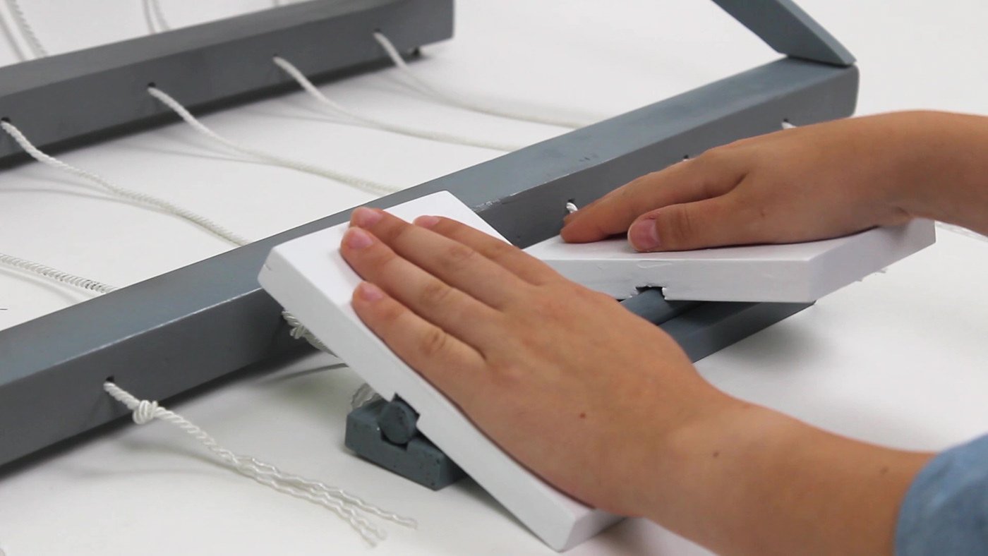 inquadratura sulle mani che muovono la pedaliera del telaio interattivo